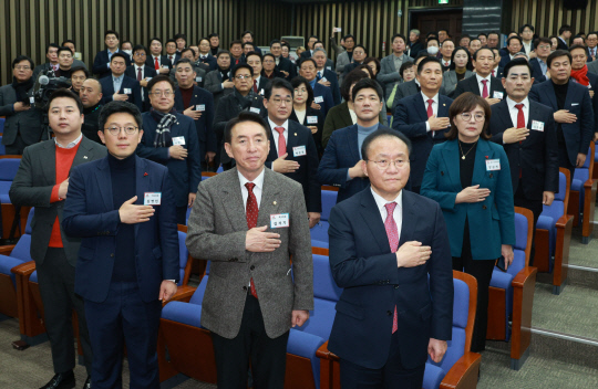 윤재옥(맨 앞줄 맨 오른쪽) 국민의힘 대표 권한대행이 18일 서울 국회에서 열린 국회의원·당협위원장 연석회의에서 참석자들과 함께 국민의례를 하고 있다.연합뉴스